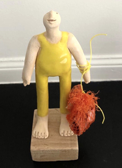 Kiki Demelinnek Strandjutter geel, Keramiek op houten sokkel met plastic zak van het strand, 14 cm, €.75,-